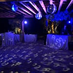 Wedding dance party with disco balls lit with blue and purple color hues.